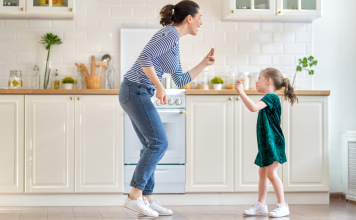 mom and daughter dancing in kitchen