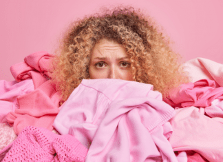 Lady with curly hair and a concerned looking face is covered with a lot of pink clothing