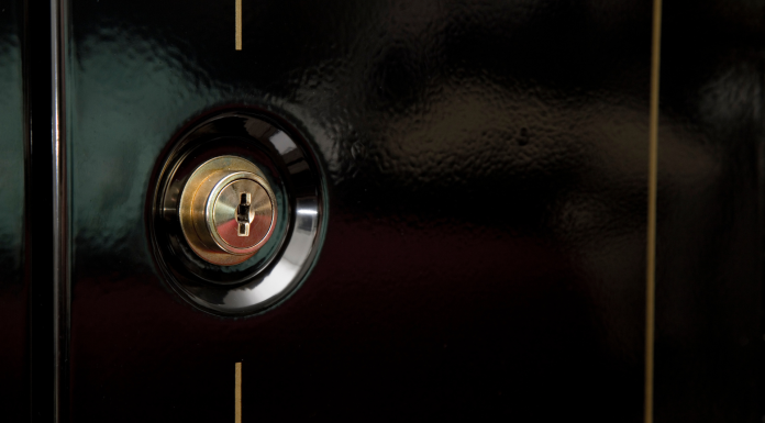 black front door with a gold lock on a gun safe
