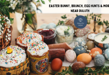 Colorful Easter eggs and Easter cakes on a table with babies breath stems, logs of meat and spreads